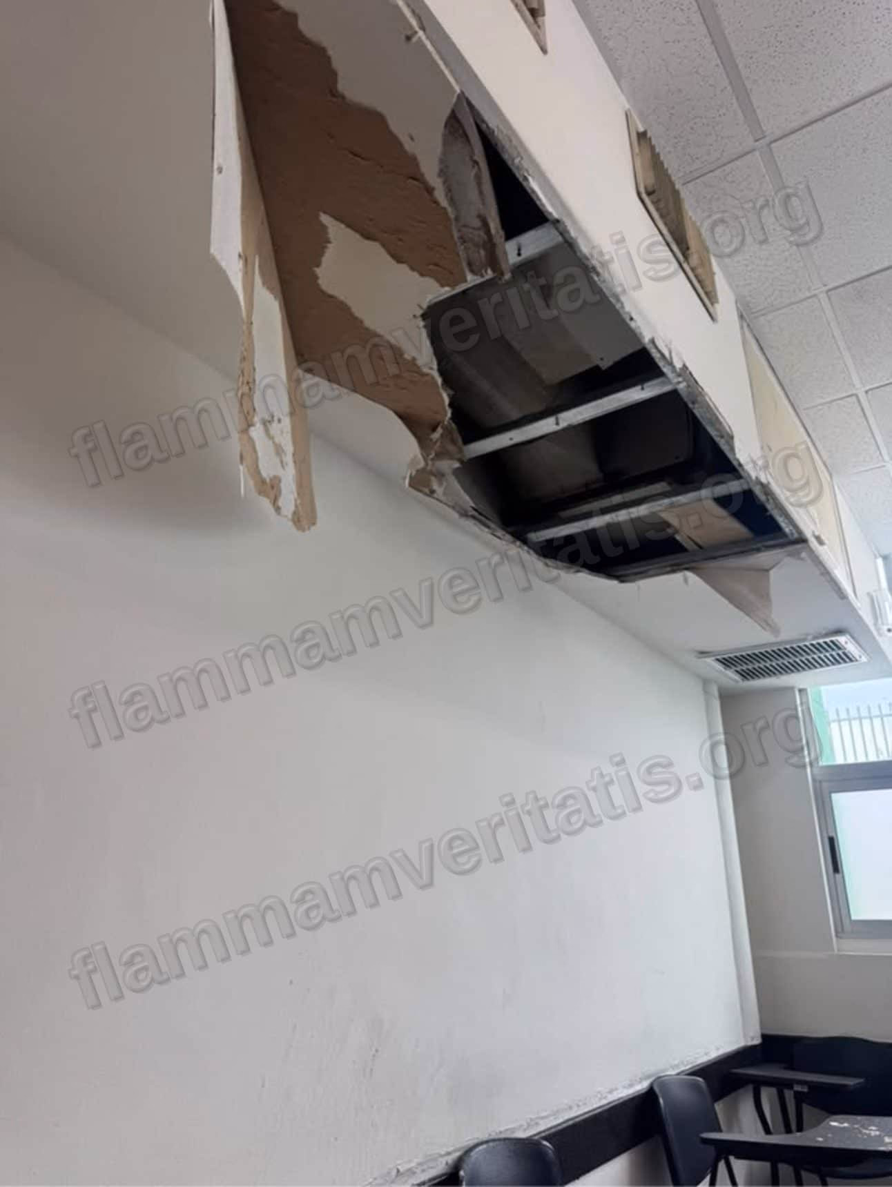 Boquete en el techo del aula 2301 donde se desprendió el aplanado, dejando expuesto el bastidor metálico de la plafonería y el ducto de aire acondicionado sobre las bancas.