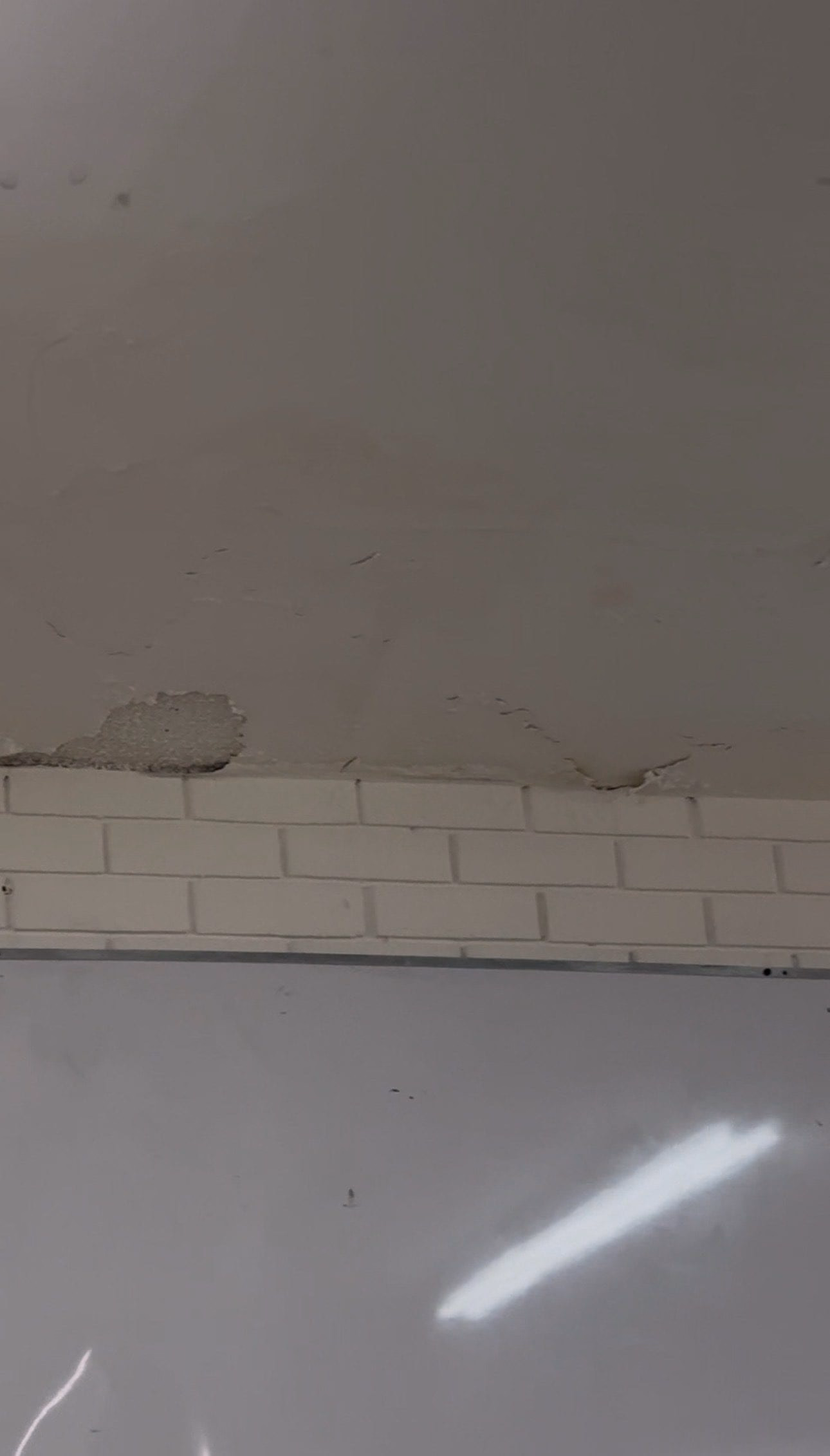 Grietas en el techo del aula 3301 y un trozo de aplanado desprendido cerca del borde con la pared de ladrillo.