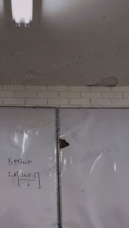 Techo del aula 3301 con grietas y un trozo de aplanado caído sobre el borde de ladrillo, encima de un pizarrón con una zona inflada y perforada.