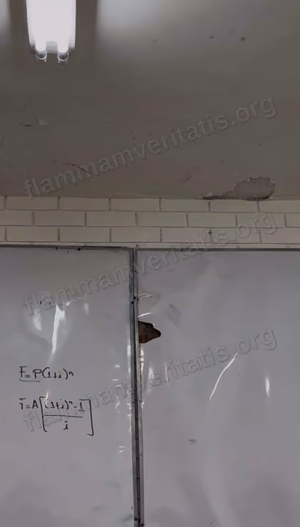 Techo del aula 3301 con grietas y un trozo de aplanado caído sobre el borde de ladrillo, encima de un pizarrón con una zona inflada y perforada.