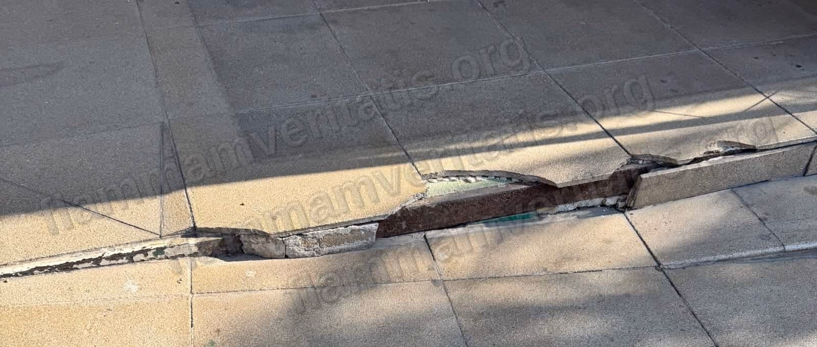 Losa de concreto partida en el borde de una rampa-escalera de acceso al Edificio 7, con una varilla metálica oxidada expuesta a lo largo de toda la grieta.
