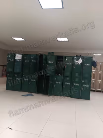 Fila de casilleros verdes metálicos marcados SIASE en el Polideportivo, varios con la puerta abierta, doblada o con papel rasgado pegado, y ropa tirada en el piso.